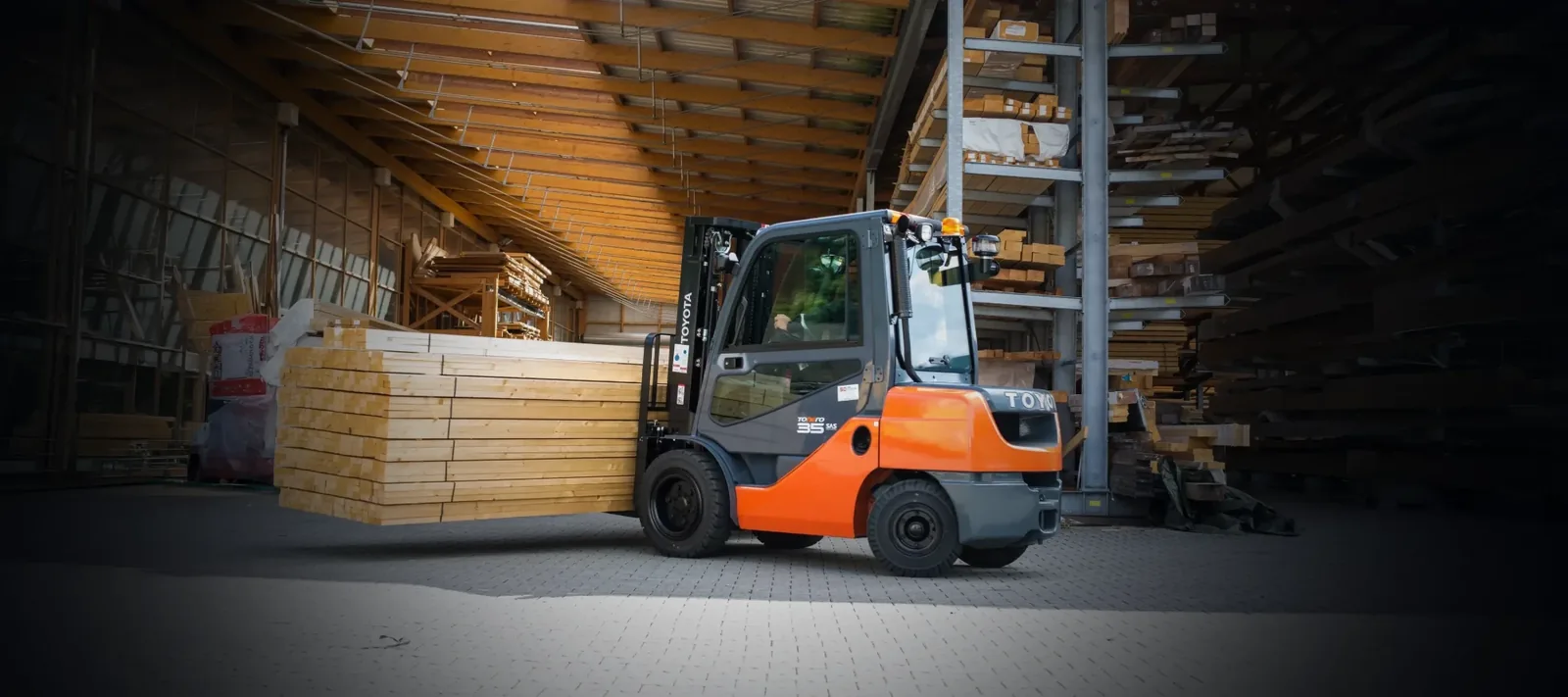 Toyota Tonero transportiert ein Holzpaket durch die Lagerhalle