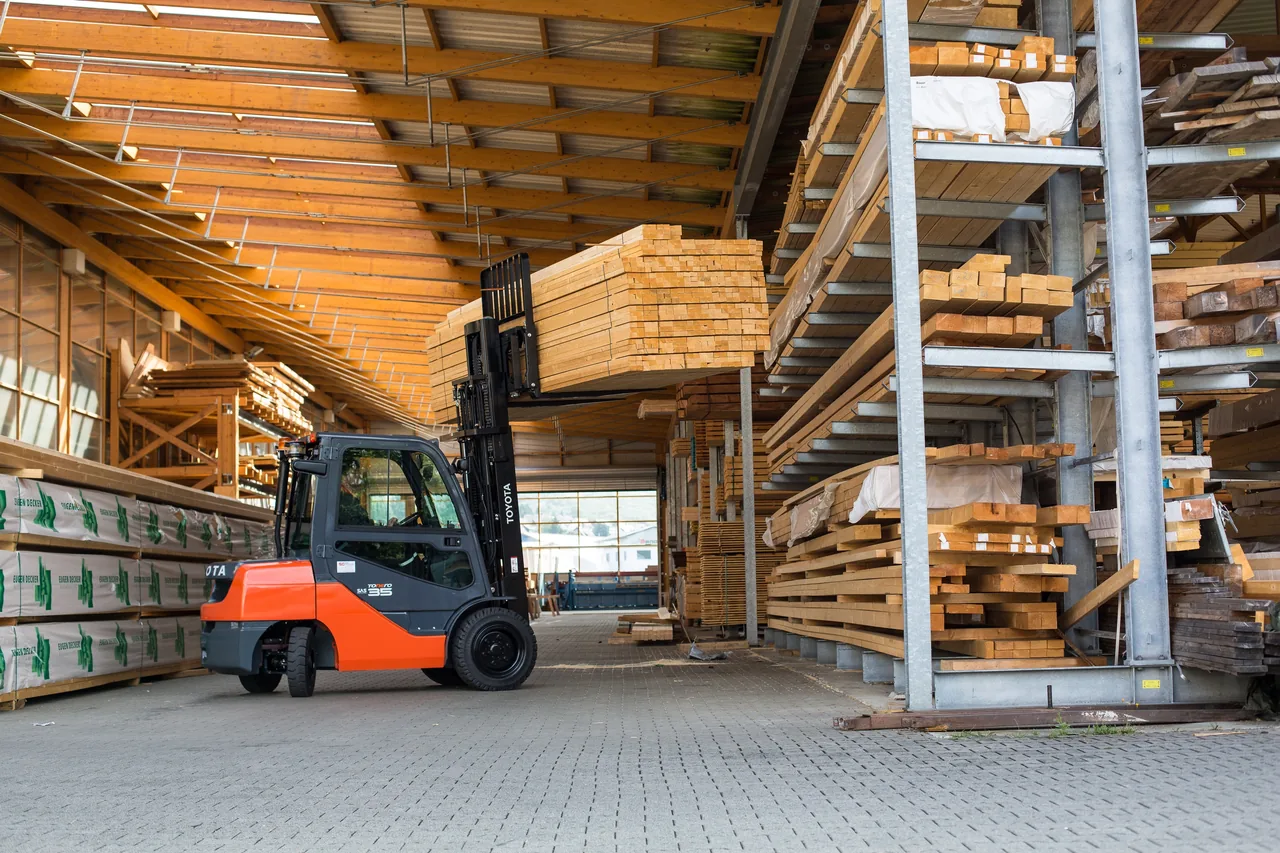 Toyota-Stapler belädt einen Lkw im Holzlager